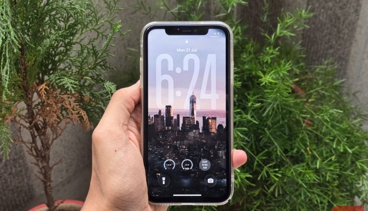 A person holding an iphone running ios 26.jpg