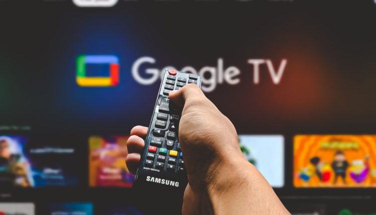 Man pointing remote control at google tv.jpg