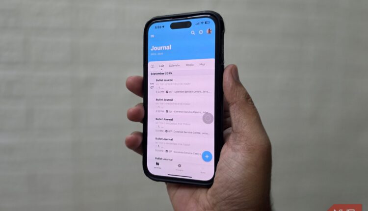 Hand holding a phone with day one journal entries on screen.jpg