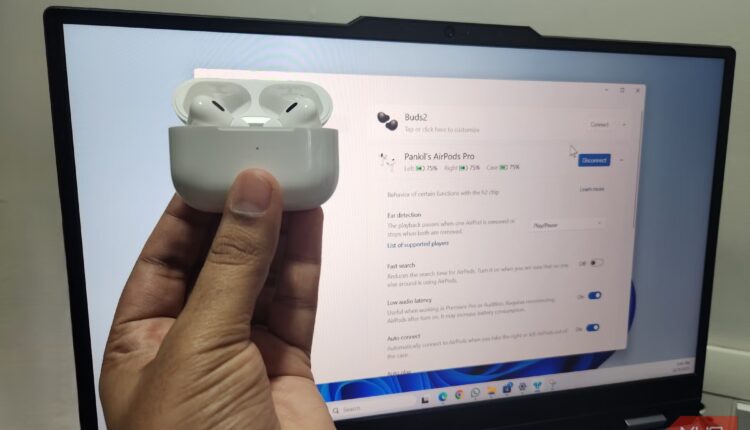 Holding airpods pro in front of a laptop.jpg