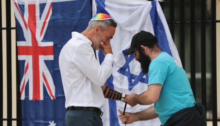 Prays rabbi stand outside bondi 117356168 e1765769207459.jpg