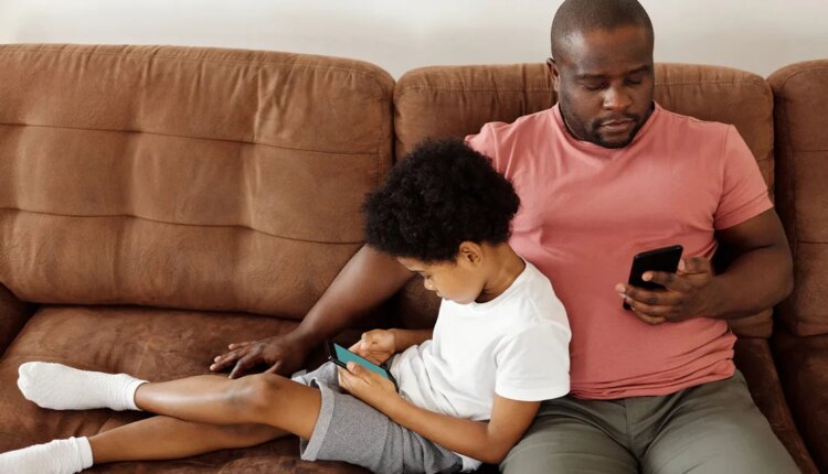 Father and son bonding over smartphones while relaxing on a comfortable couch at home.jpg