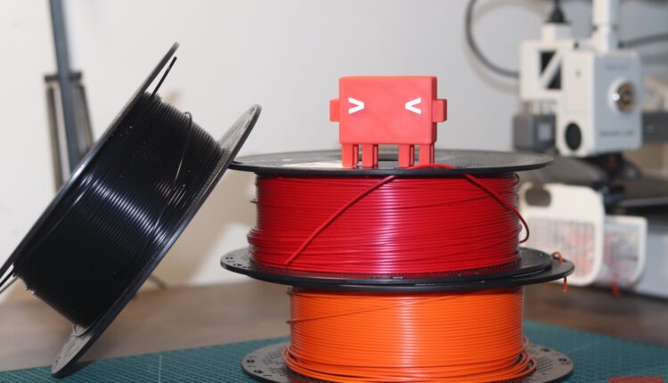 Claude code mascot on top of filament spools.JPG