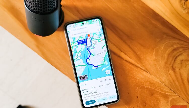 Smartphone displaying google maps navigation route new york with microphone on wooden desk.jpg